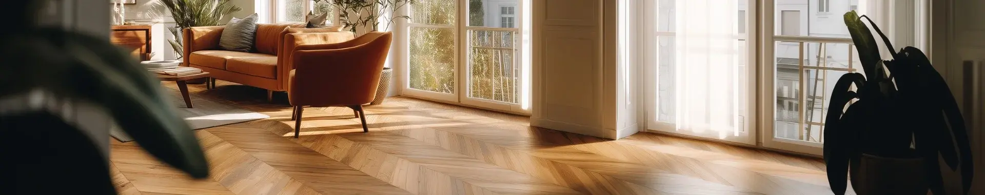 Gemütliches Wohnzimmer mit Retro Sofa, Sessel und hochwertigem Parkettboden. Durch bodentiefe Fenster tritt Tageslicht und Sonne in das Zimmer.